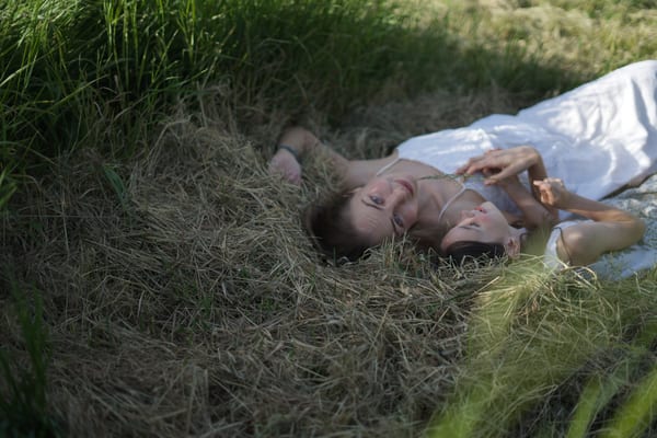 Two people in a natural outdoor setting, wide horizontal portrait