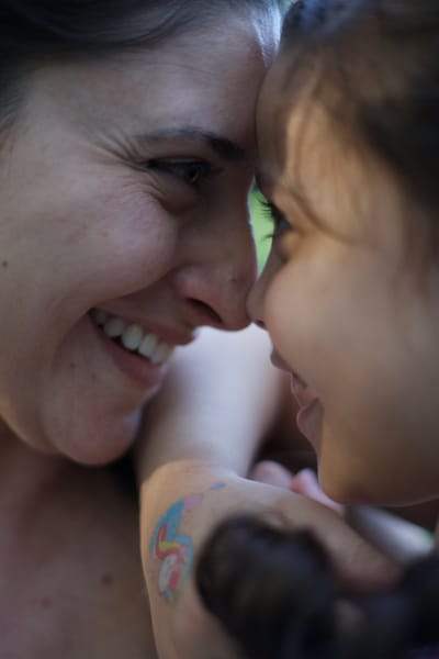 Mother and daughter touching foreheads, intimate close-up with soft light