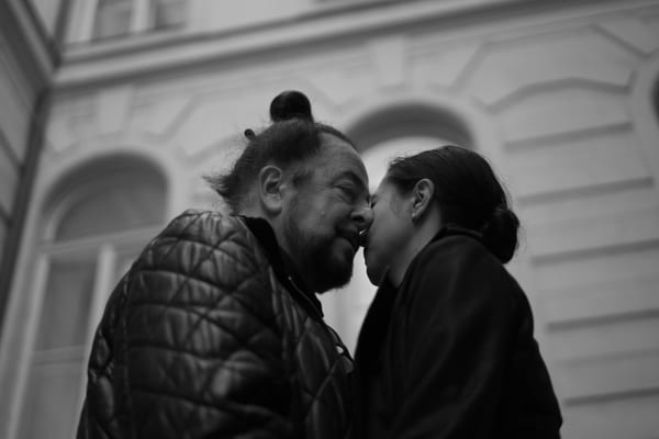 Couple nose to nose in a courtyard, seen from below