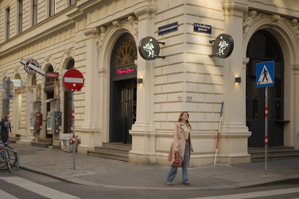 Woman on a Vienna street corner with Ringstrasse architecture and a Schellinggasse street sign