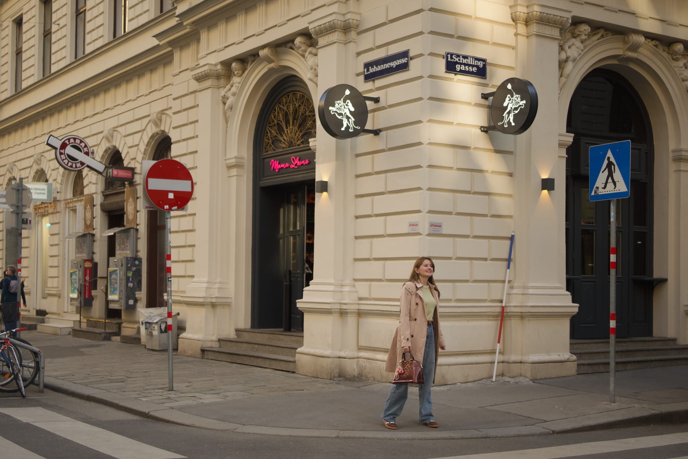 Woman on a Vienna street corner with Ringstrasse architecture and a Schellinggasse street sign