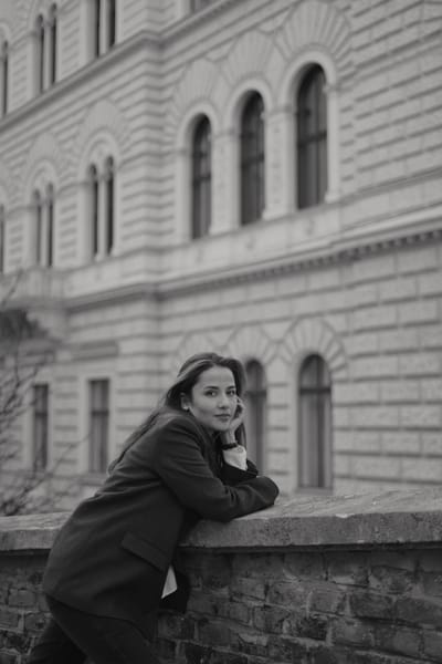 Woman leaning on a wall in front of a historic Ringstrasse building in Vienna